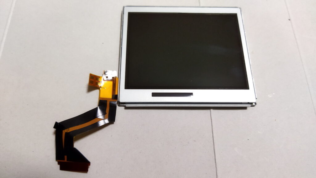 DS Lite 上側　LCD パネルのオレンジ色の FPC に、黒い絶縁テープを半分の幅に切ってから貼ります。補強しないと FPC が切れます。