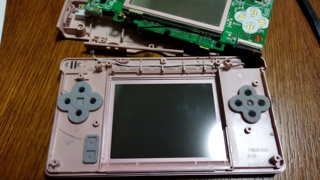 DS Lite 白い線を本体ケース内側のくぼみに取り付けます。　緑色の基盤を取り付けるときに、オレンジ色の FPC を引っ張ってしまうと切れます。慎重にゆっくりとボタンゴムの上に置いてください。