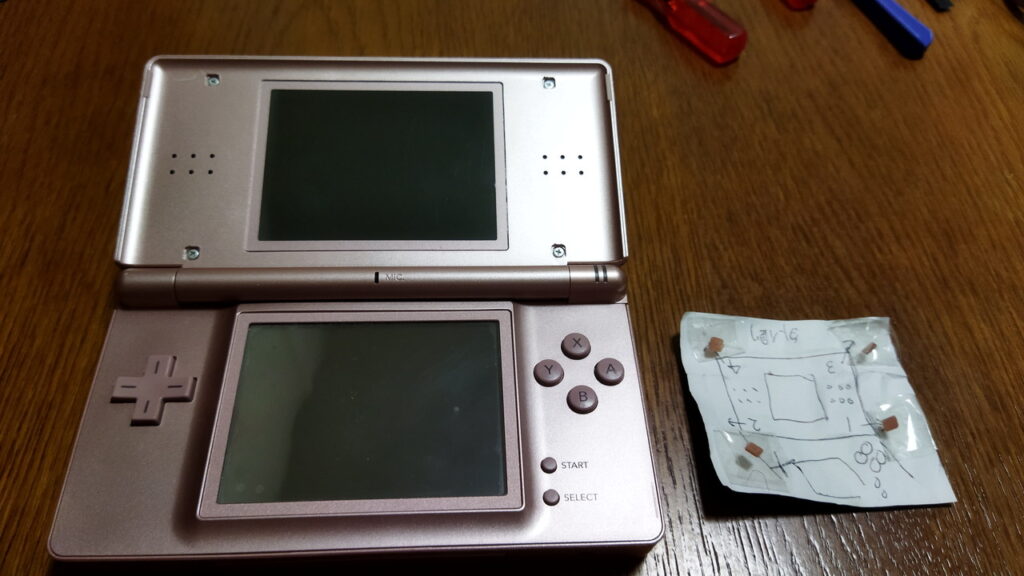 DS Lite 最後に上画面のネジ隠しカバーを取り付けます。（粘着力が無ければ、両面テープを貼り換えます。）